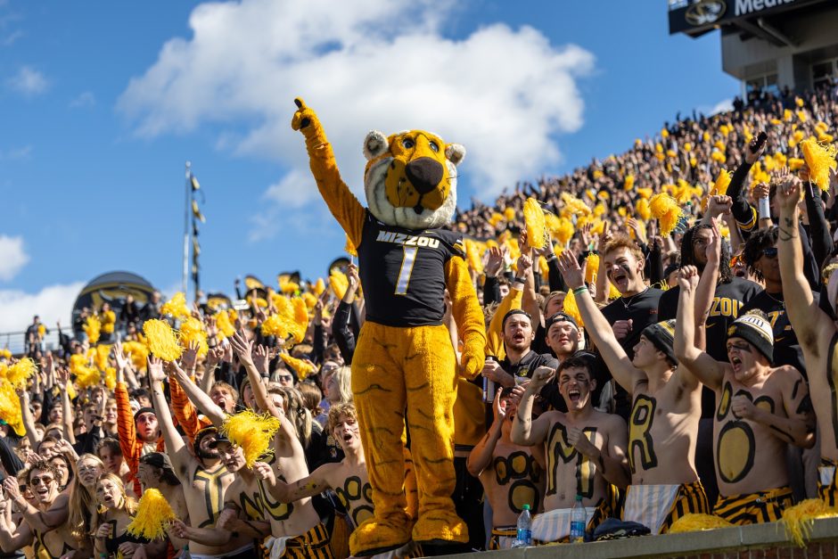 Truman the Tiger stands in front of students at a football game