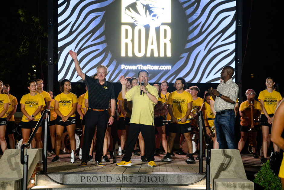 Men wave from stage
