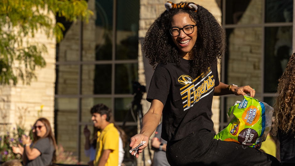 Student hands out candy at parade