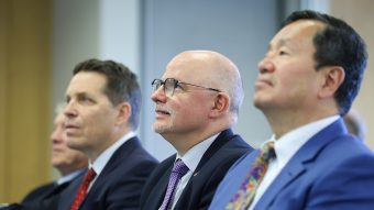 Three men sitting in a row