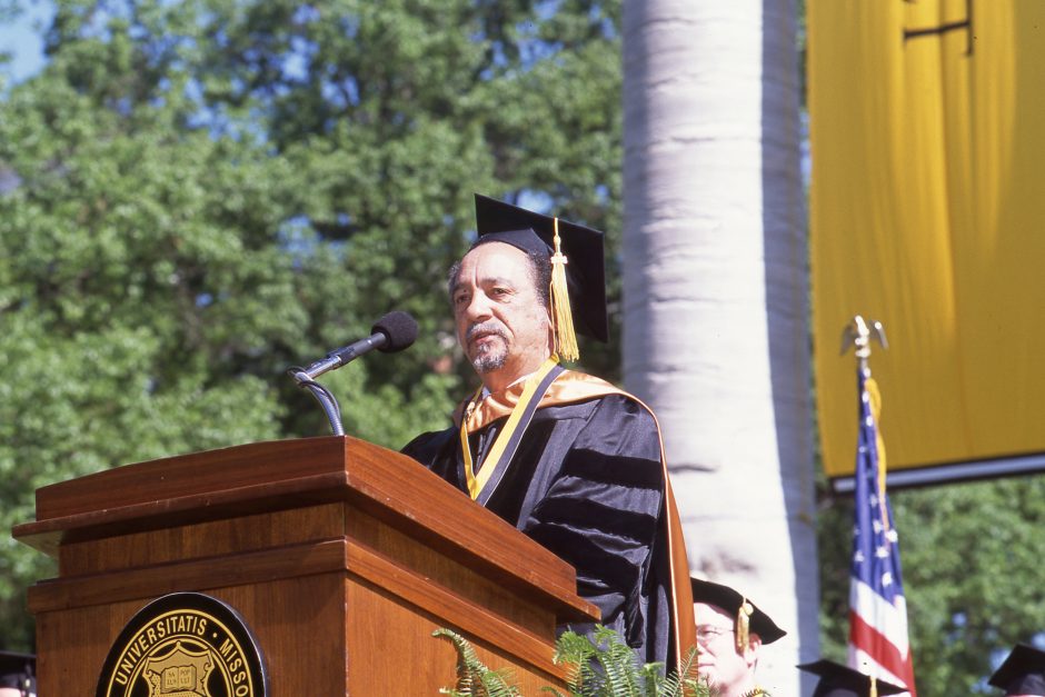 Man at a podium in commencement regalia