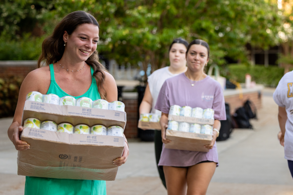 Students carry boxes of canned food
