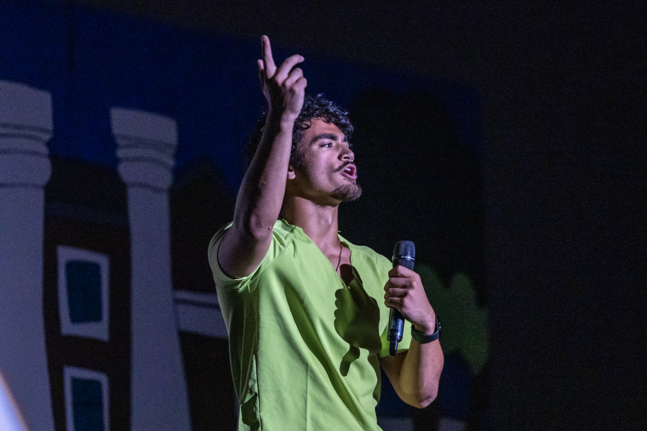 Student lifts hand while singing