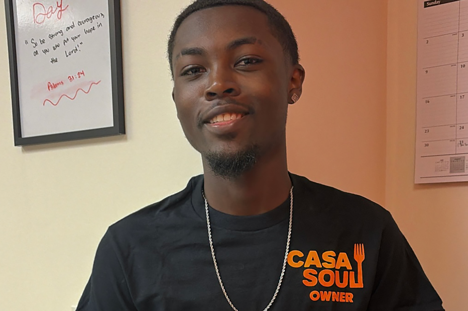 A student posing in his retail shop.