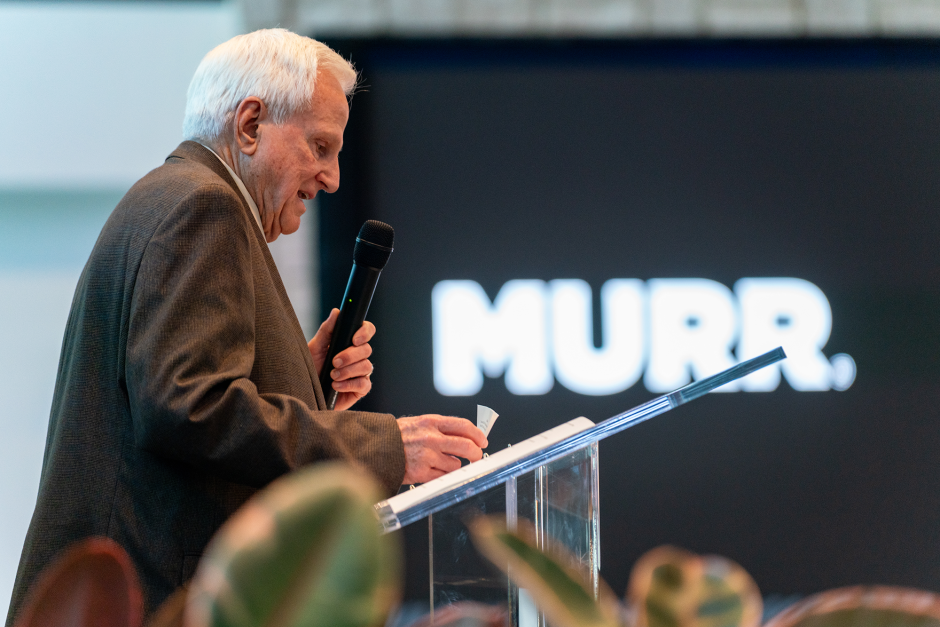 Man at podium with MURR signage