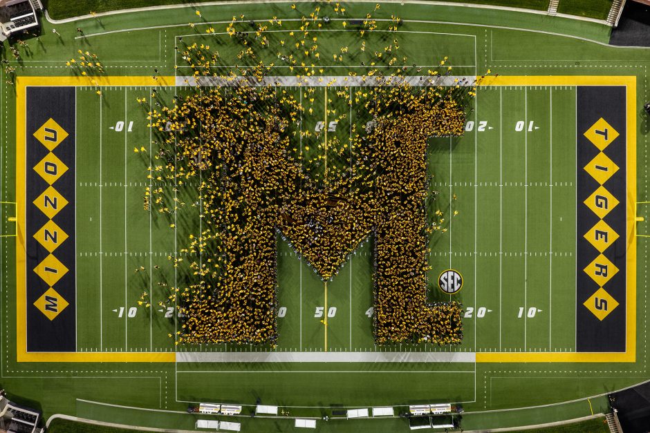 Students form the letter M on a football field