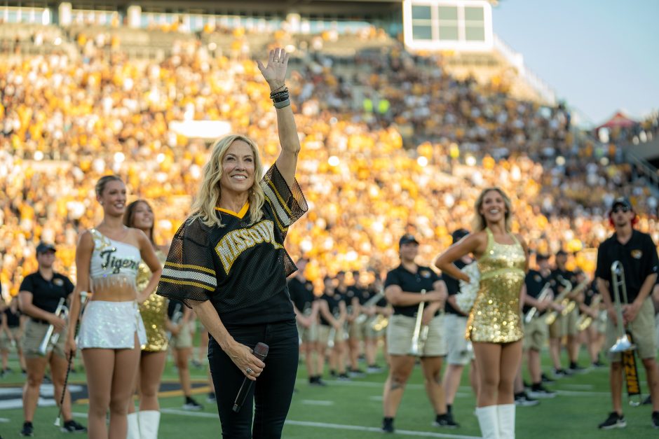Person waving to crowd on football field