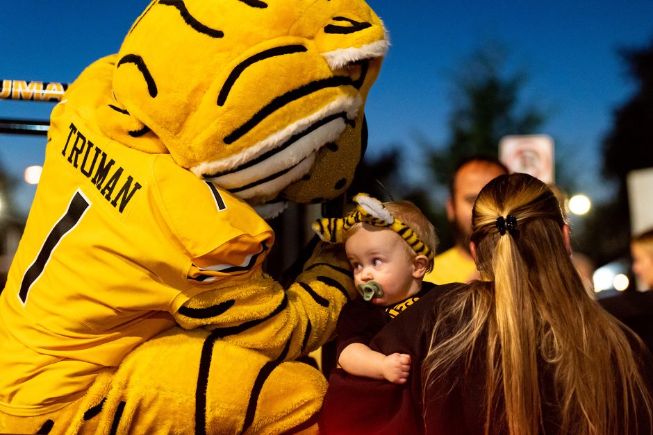 Truman the Tiger greeting a baby