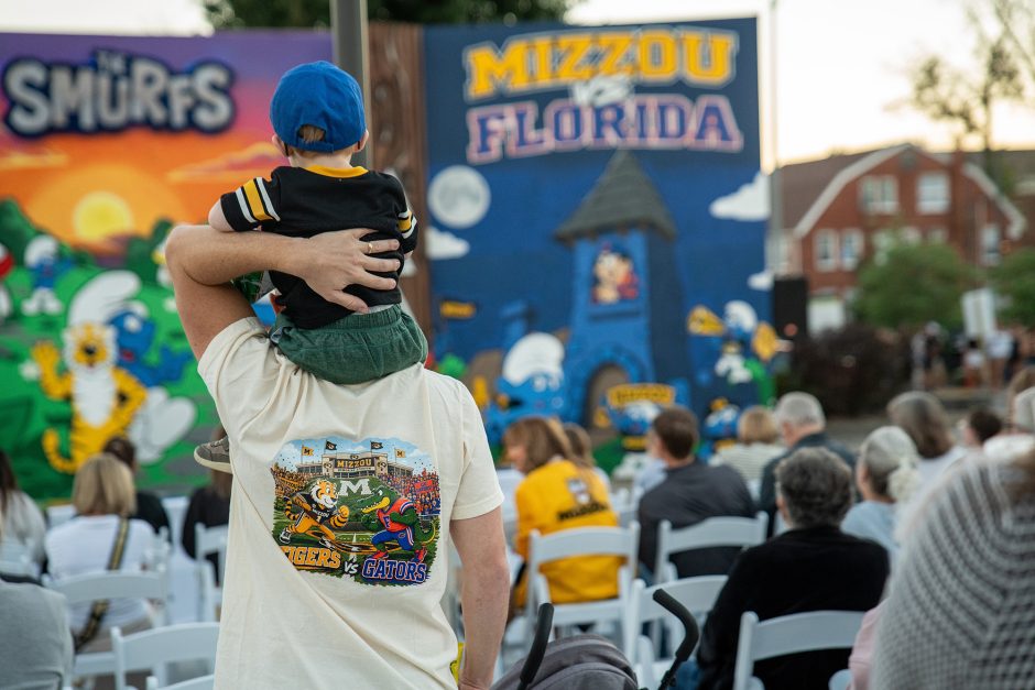 A child on father's shoulders looking at campus decorations