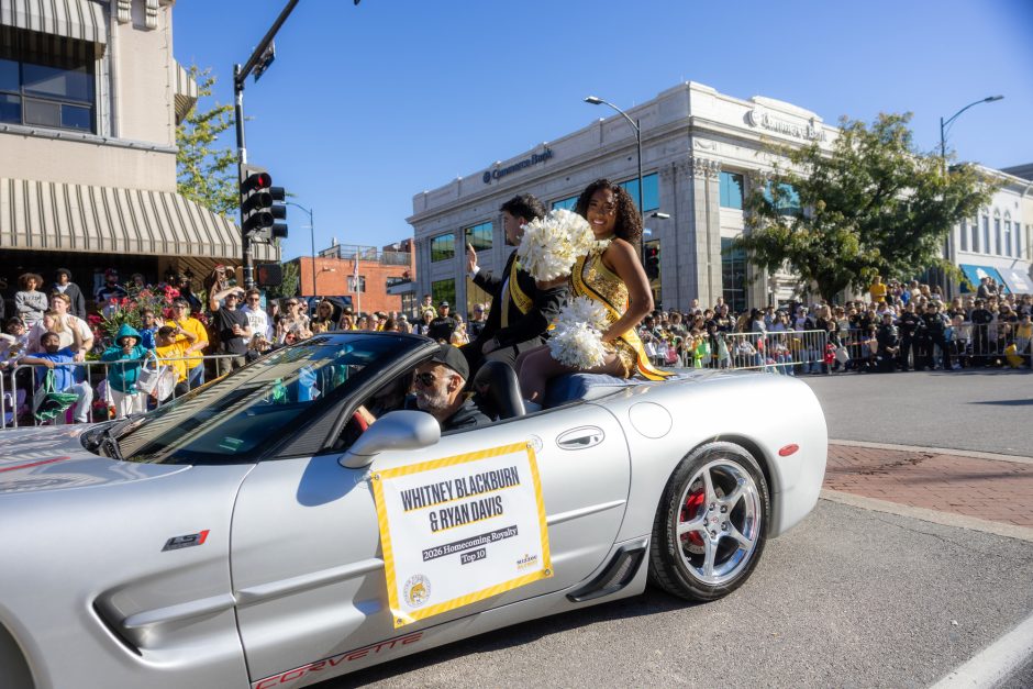Convertible with people sitting on the back in the Homecoming parade