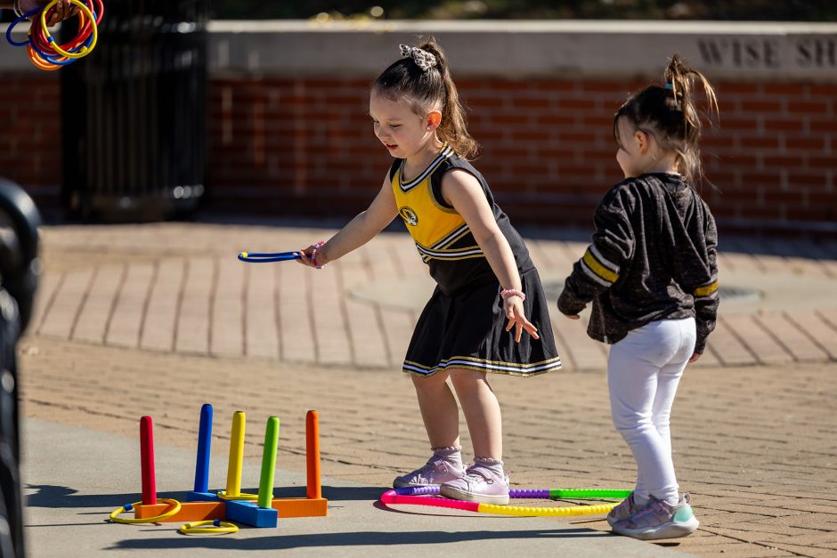 Small children dressed in Mizzou gear playing outside