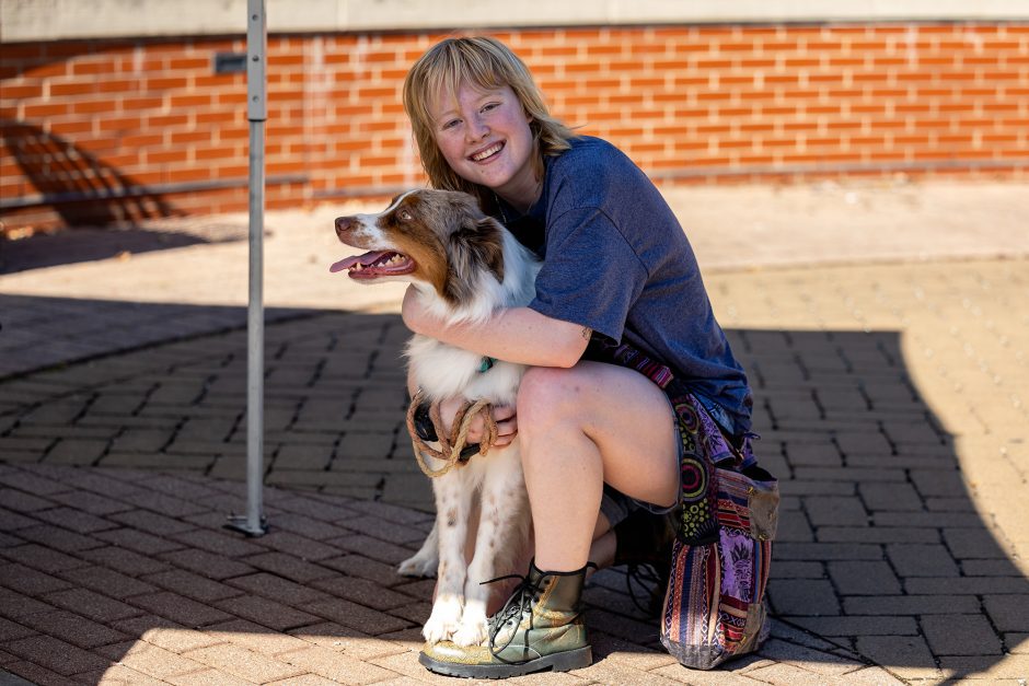 A student hugging a dog