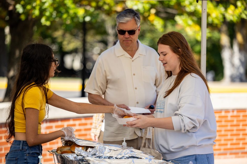 Two people being served food at a picnic