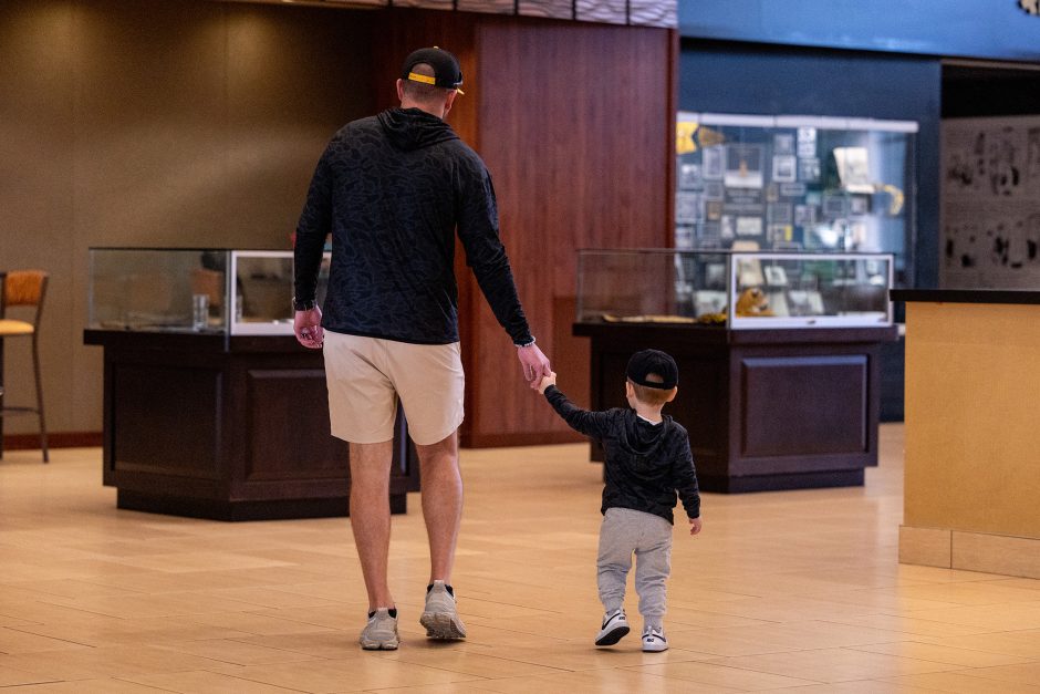 A grown-up holding the hand of a young child